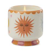 The Orange Blossom - A Dopo 8 oz Candle, with hand-painted sun face and vibrant orange, pink, and yellow patterns, is perfect for display or adding a touch of Mediterranean-inspired fragrance to your space.