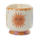 The A Dopo Sun Candle - Orange Blossom features a lit ceramic candle in a sun face holder with hand-painted details and vibrant orange, pink, and yellow accents.