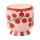 The A Dopo Tomato Vine Candle - Heirloom Tomato features a pink ceramic holder with heirloom tomatoes on green vines and a base accented by bold red and white vertical stripes.