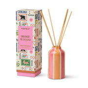 The Orange Blossom - A Dopo 4 oz Diffuser features a pink and orange striped ceramic bottle, wooden reeds, and comes in a decorative box with colorful patterns and animal illustrations.