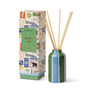 A colorful box labeled "Misted Lime - A Dopo 4 oz Diffuser" stands beside a blue and green striped ceramic bottle filled with reed sticks, set against a white background.