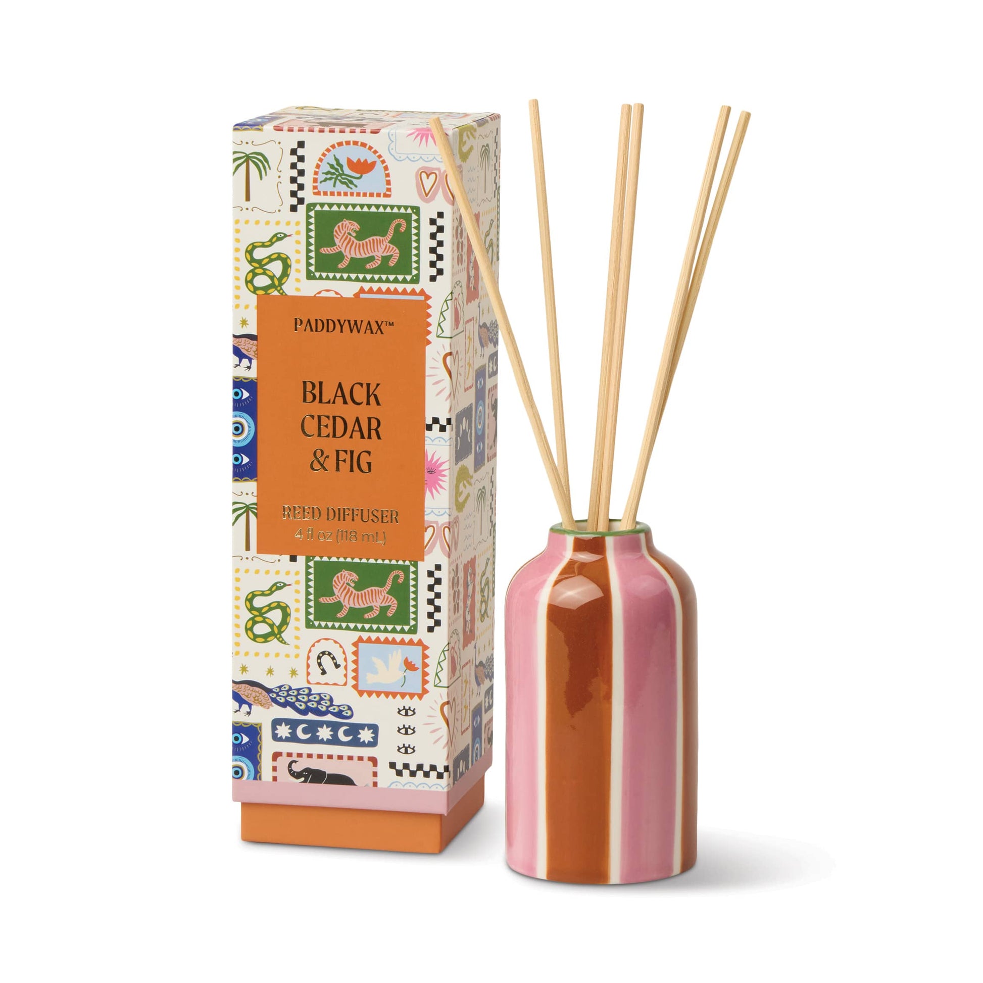 The Black Cedar & Fig - A Dopo 4 oz Diffuser features a pink and brown striped ceramic bottle with four wooden reeds, beside a vibrant box adorned with animal illustrations.