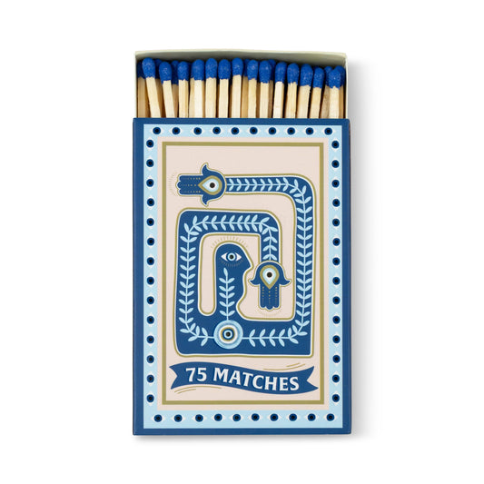 A Dopo "Eye" - 75ct Boxed Matches feature blue-tipped matches in a blue and beige box decorated with hands, an eye, curved lines, and dots. Perfect for lighting your A Dopo candle, the matches are neatly arranged inside.