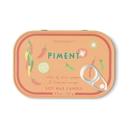 The Piment - Bistro 4.5 oz Tin Candle features a vibrant orange tin adorned with whimsical illustrations of chili peppers and mango slices. The playful label showcases notes of chili pepper and tropical mango, beautifully capturing the signature Piment fragrance in this fruit-and-spice-inspired soy wax candle. Weighing 4.5 oz / 127 g, it comes complete with a convenient pull-tab lid for easy use.