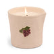 The Bistro Candle - Bordeaux Grape comes lit in a cream ceramic holder with a raised design of red berries and green leaves.