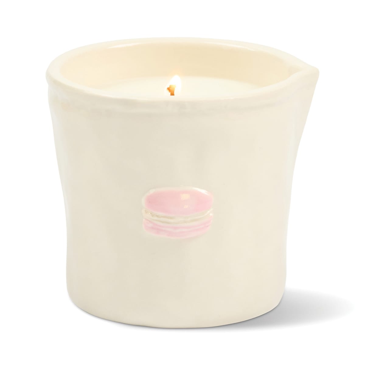 A lit Macaron - Bistro 8 oz Candle in a cream-colored, food-safe ceramic vessel features a small pink macaron illustration on the front, a slight lip on one side, and a smooth, glossy finish.