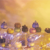 A group of colorful glass insulators arranged on a surface covered with transparent plastic, set against a yellow and purple gradient background.