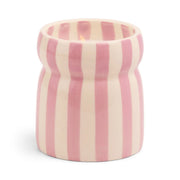 The Grecian Sand - Cabana 6.5 oz Candle features a ceramic vessel with vertical pink and white stripes, holding a lit candle that's ideal for displaying hand painted candles or adding refreshing coastal scents to your space.