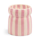 The Cabana Lavender Candle - Grecian Sand features a lit cream and pink vertically striped ceramic vessel with a rounded, slightly flared design—perfect for adding relaxed coastal charm to your home.