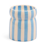 The Lost At Sea - Cabana 6.5 oz Candle features a ceramic cup with vertical blue and white stripes, a slightly indented middle, and is shown against a plain white background.