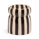 The Cabana Black Candle - Lava Stone is a ceramic vessel with black and white stripes, featuring a lit candle inside.