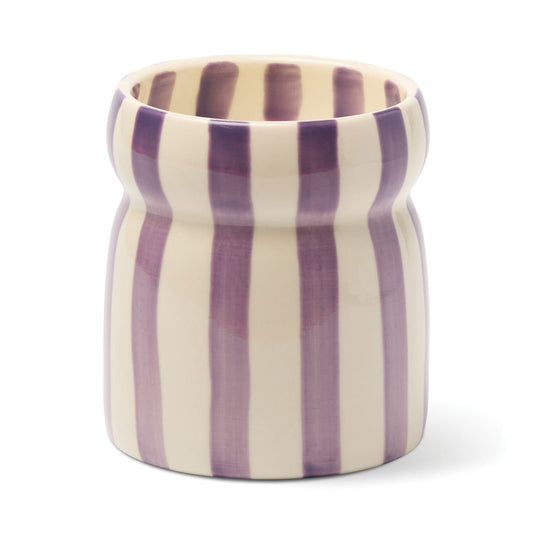 A 6.5 oz Waikiki Waters - Cabana candle, housed in an elegant ceramic vessel with a rounded rim and a smooth, glossy finish, featuring vertical purple and white stripes—evoking the refreshing ambiance of Waikiki Waters.