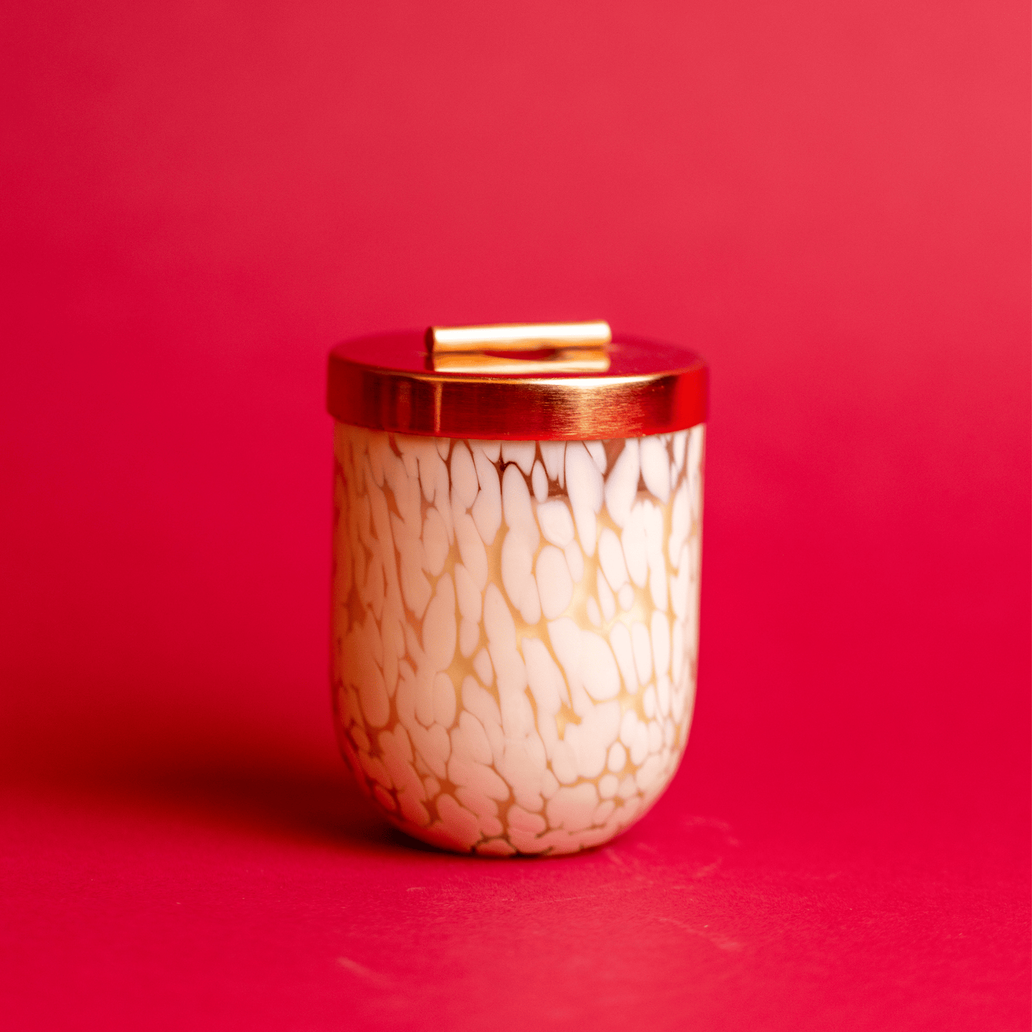 White Blown Glass Candle with lid on on red background