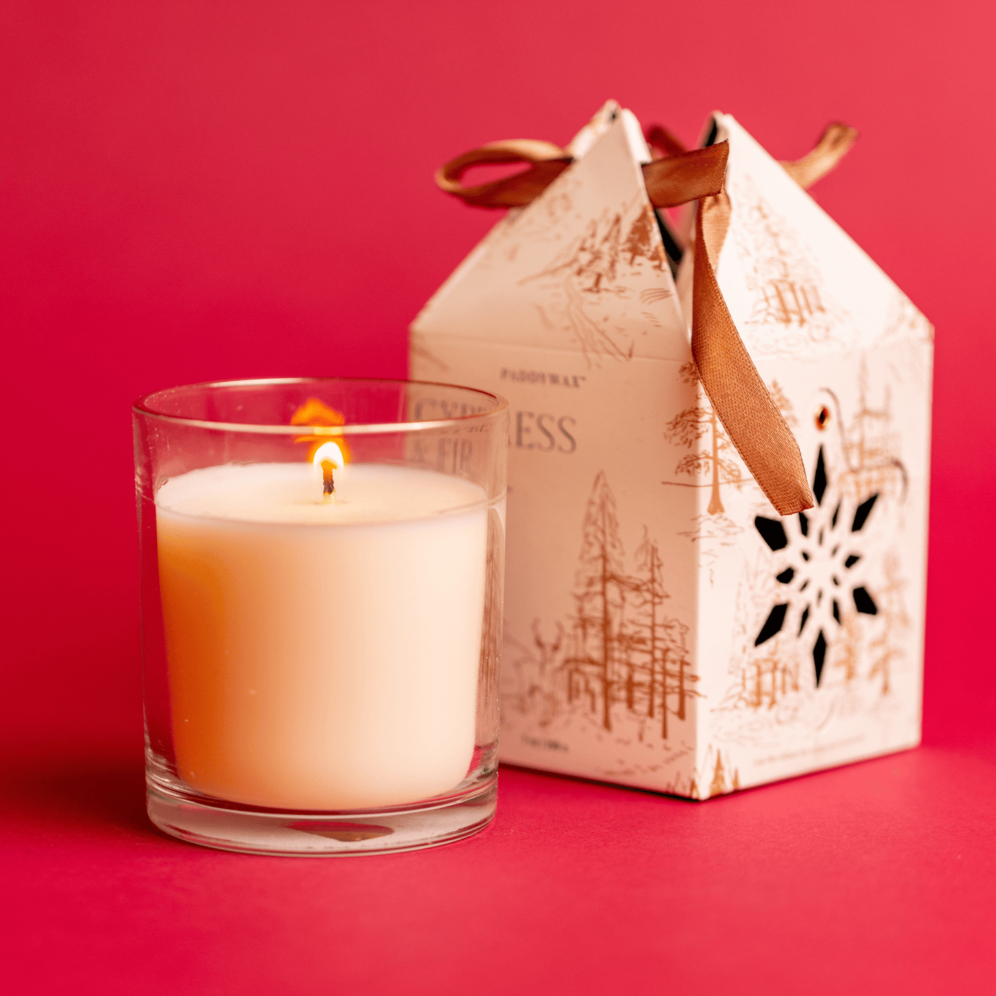 7 oz Glass Candle lit with Ornament Gift Box on red background
