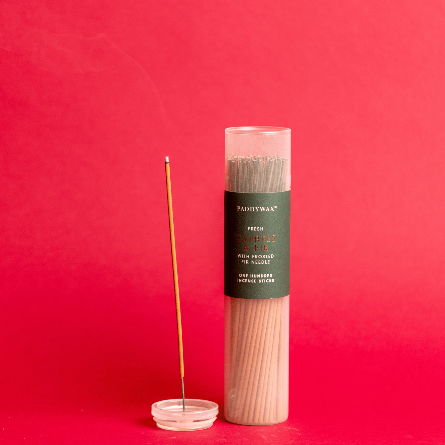 Cypress + Fir - Incense Sticks on red background; one stick lit