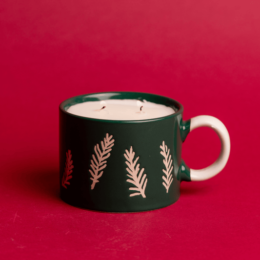 Lit Cypress & Fir - 8oz Green Ceramic Mug candle on a red background