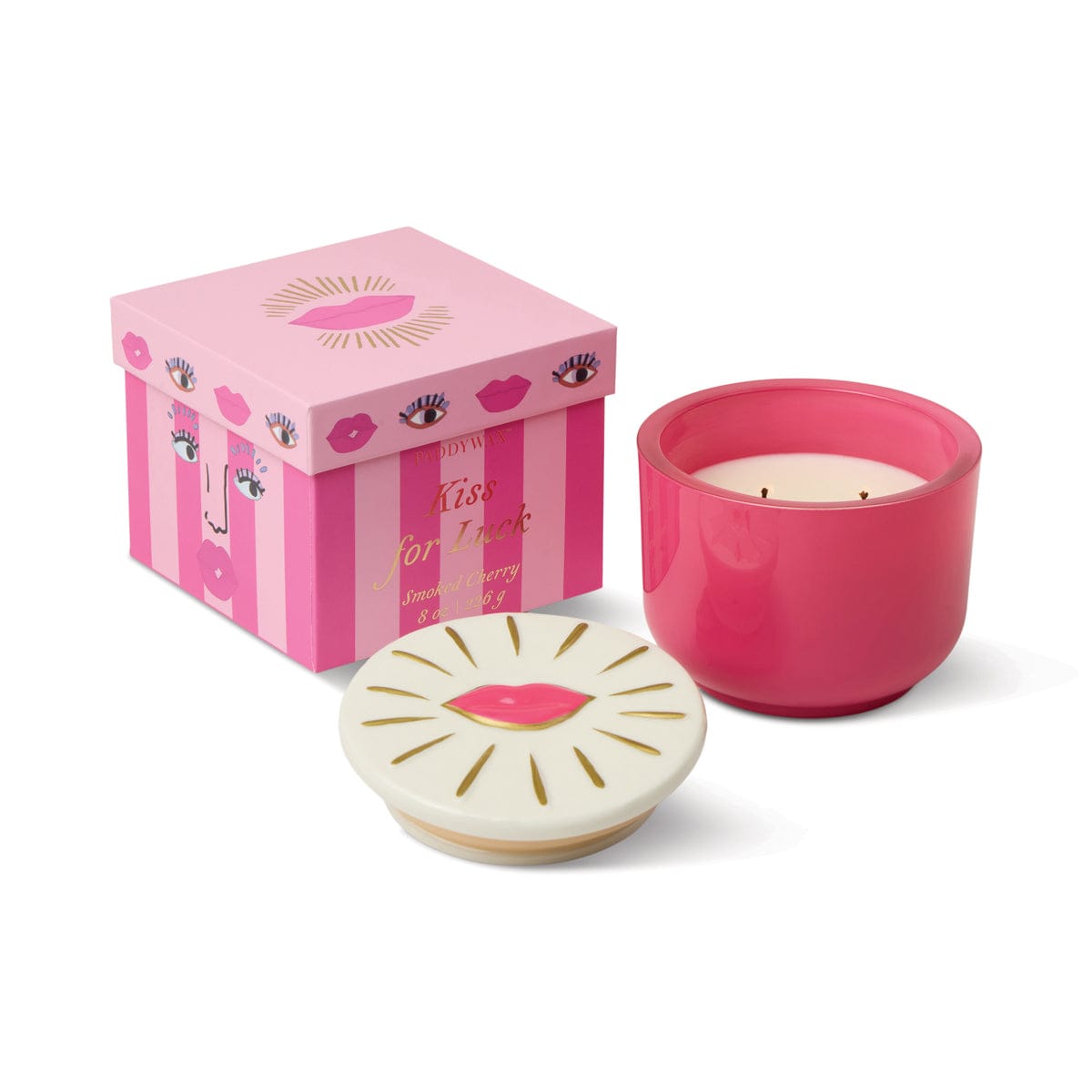 The Smoked Cherry - Charmed 8oz Candle features a red lips lid and comes in a pink striped Kiss for Luck box—making this stylish glass candle both charming and giftable.
