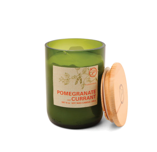 The Pomegranate + Currant - Eco 8 oz Candle features soy wax in a green glass jar with a wooden lid, decorated with elegant text and leafy branch artwork—a charming, eco-friendly scent experience.