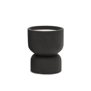 The Palo Santo Suede - Form 6 oz Candle features a small, black matte ceramic holder with a modern hourglass design. It includes a white candle and is ideal for desert-inspired decor—reuse it as a planter. Shown on a plain white background.