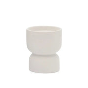 The Tobacco Flower - Form 6 oz Candle features a small, white ceramic hourglass-shaped cup that brings subtle elegance to any setting—ideal for desert-inspired decor with its refined design and clean white finish.