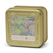 A gold tin with an embossed frame features a colorful garden path on the label, reading "Claude Monet Secret Garden - Impressionist 3.5 oz Tin Candle.