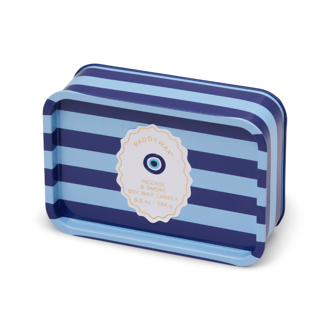 A rectangular tin candle container with blue and navy stripes labeled "Incense & Smoke - A Dopo 6.5 oz Tin Candle"—a perfect Mediterranean-inspired addition for your space.