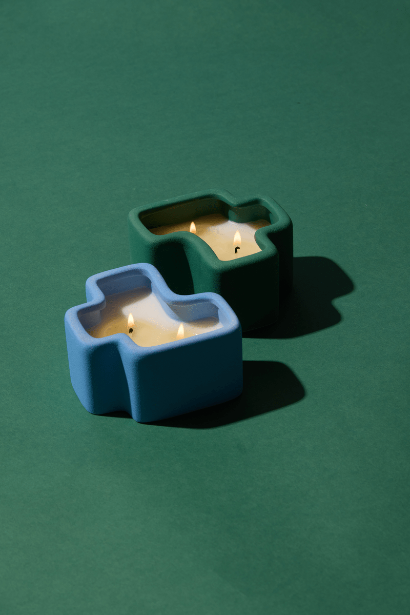 Two Jigsaw candles on a green background
