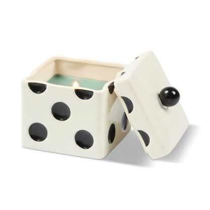 A lit Misted Lime - Lucky Dice 10 oz Candle in a square, die-shaped ceramic container with a matching removable lid.