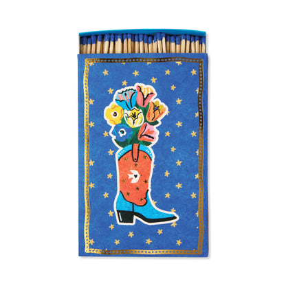 Cowboy Boot - Large Rectangle Boxed Matches feature a vibrant flower-filled red cowboy boot on a blue background with yellow stars. Blue match tips add western décor charm.