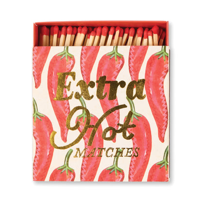 An open Extra Hot - Square Boxed Matches with red-tipped matches inside. The box shows chili pepper illustrations and gold text—an eye-catching host gift.