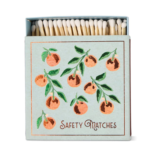 The Oranges - Square Boxed Matches feature a hand-painted light blue cover with an orange branch of nine oranges and green leaves, plus Safety Matches printed at the bottom.