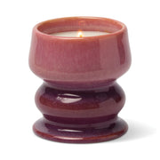 A lit Wild Fig & Cedar - Melt 8.5 oz Candle in a glossy, purple-pink ceramic holder with a rounded, hourglass shape, shown against a white background.