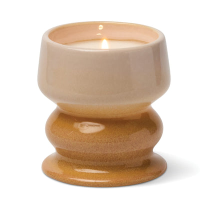 The Smoked Pistachio - Melt 8.5 oz Candle features an irresistible gourmand fragrance and comes in a glossy, two-tone ceramic holder with a wide base and a beige-to-tan gradient finish, filling your room with the warm scent of smoked pistachio when lit.