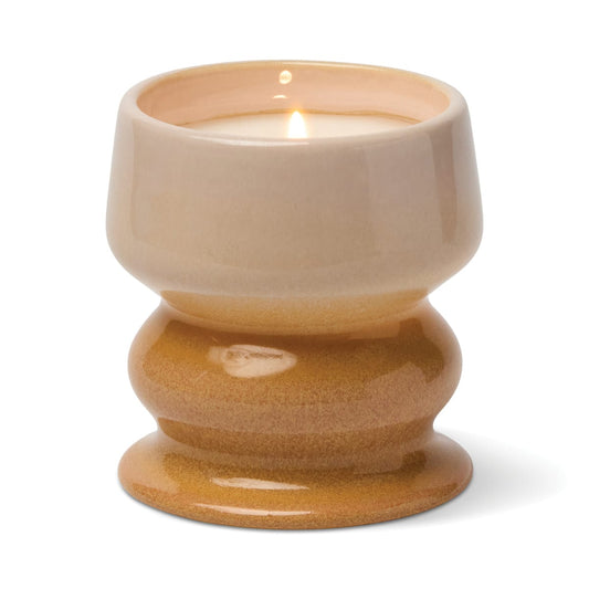 The Smoked Pistachio - Melt 8.5 oz Candle features an irresistible gourmand fragrance and comes in a glossy, two-tone ceramic holder with a wide base and a beige-to-tan gradient finish, filling your room with the warm scent of smoked pistachio when lit.