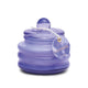 The Beam 3oz Glass Candle - Lavender features a small, round purple glass jar with a matching lid and tag, ideal for adding relaxation and fragrance to any space.