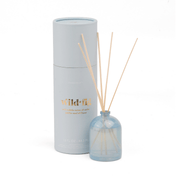 A pale blue milky glass Wild Fig - 1.5 oz Diffuser with wooden reeds sits next to a matching cylinder labeled in gold, offering a refreshing wild fig scent; further details appear on the container.