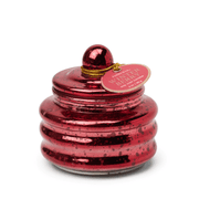 The Winter Berry - Beam 3 oz Candle features shiny red, ribbed glass with a round lid and gold string holding the label. Its speckled, reflective finish makes it ideal for holiday gifting or stocking stuffers, shown on a white background.