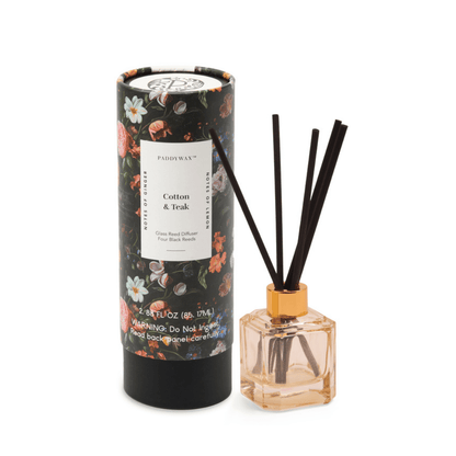 Reed diffuser with floral packaging on a white background