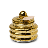 The Cypress & Fir - Beam 3 oz Candle comes in a shiny gold, beehive-shaped jar with a round lid and tag, featuring black speckles. Gift-ready for the holidays, it makes an ideal stocking stuffer.