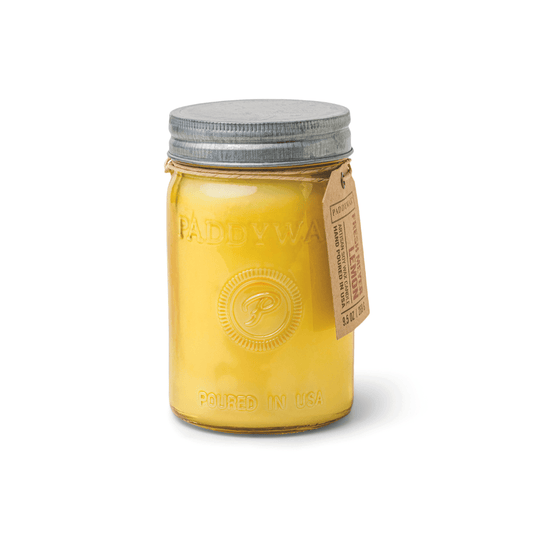 Yellow candle in a glass jar with a metal lid on a white background