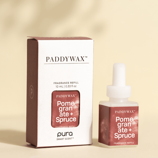 Paddywax Pomegranate and Spruce Pura fragrance refills on a pale background with light shadow