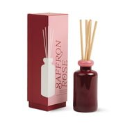 The Saffron Rose - Stack 3.2 oz Diffuser comes in a red glass bottle with a pink top and wooden reeds, displayed next to its matching box decorated with a white bottle illustration for modern, continuous fragrance.