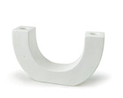 The U Taper Holder - White is a ceramic candle holder with brown speckles, flat sides, and small circular openings at the top of each end. It stands upright on flat surfaces.