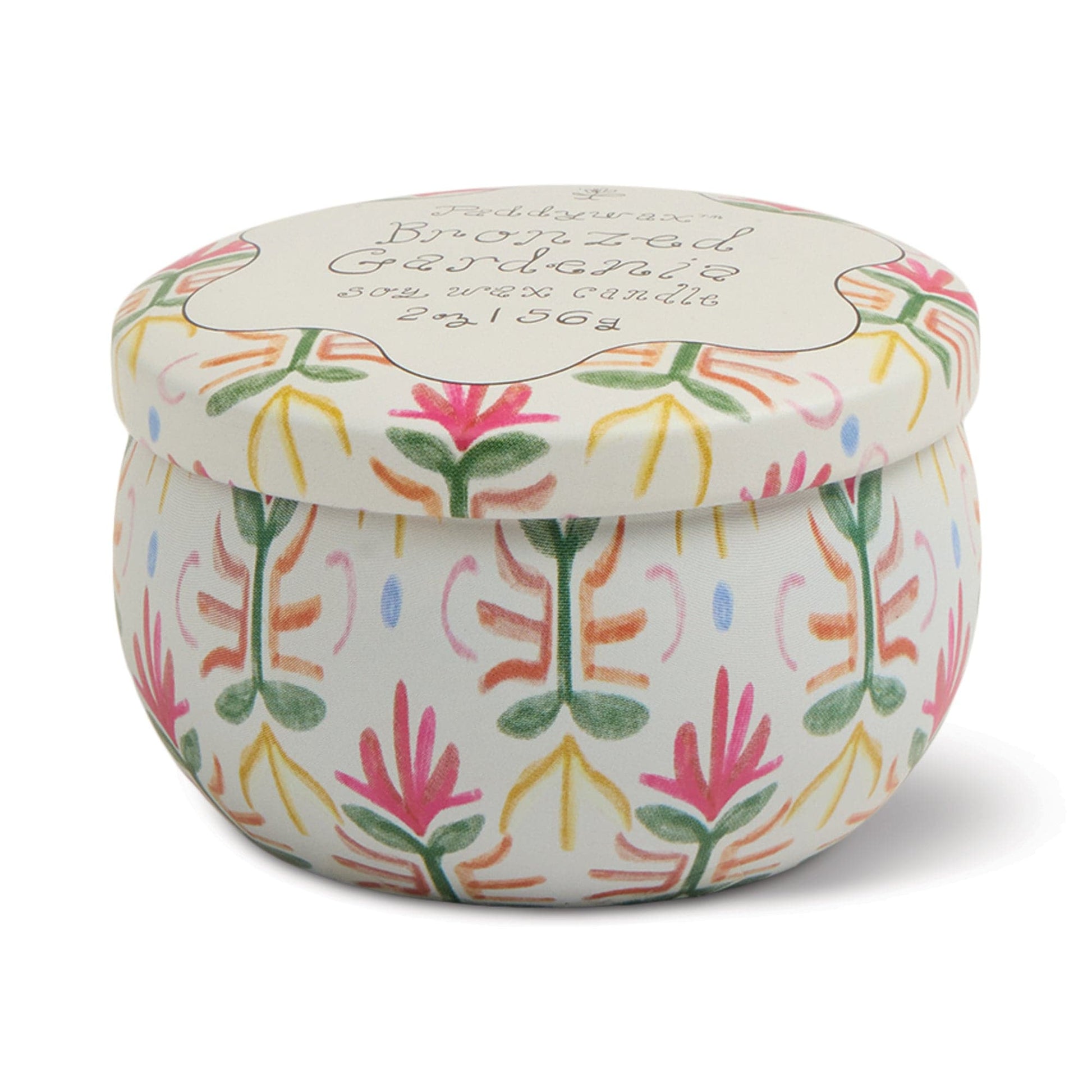 The Bronzed Gardenia - Tulip 2 oz Tin Candle features a round, white tin adorned with pink, green, and yellow floral patterns. It evokes creamy florals and sunlit citrus, with a matching lid topped by cursive writing.