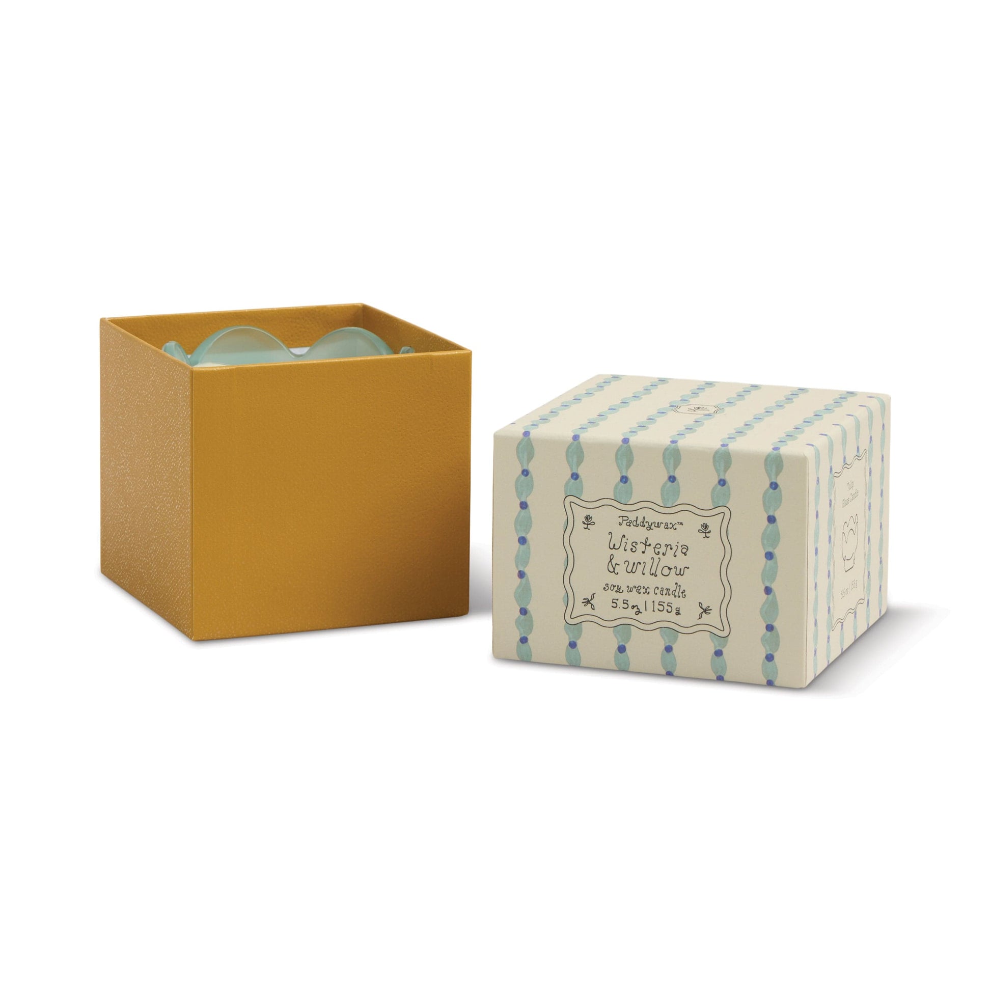 A yellow box with a light blue interior sits next to a patterned lid labeled Wisteria & Willow. Inside, the 5.5 oz Tulip Candle in a teal glass vessel peeks out, adding an elegant botanical touch with its stylish design.