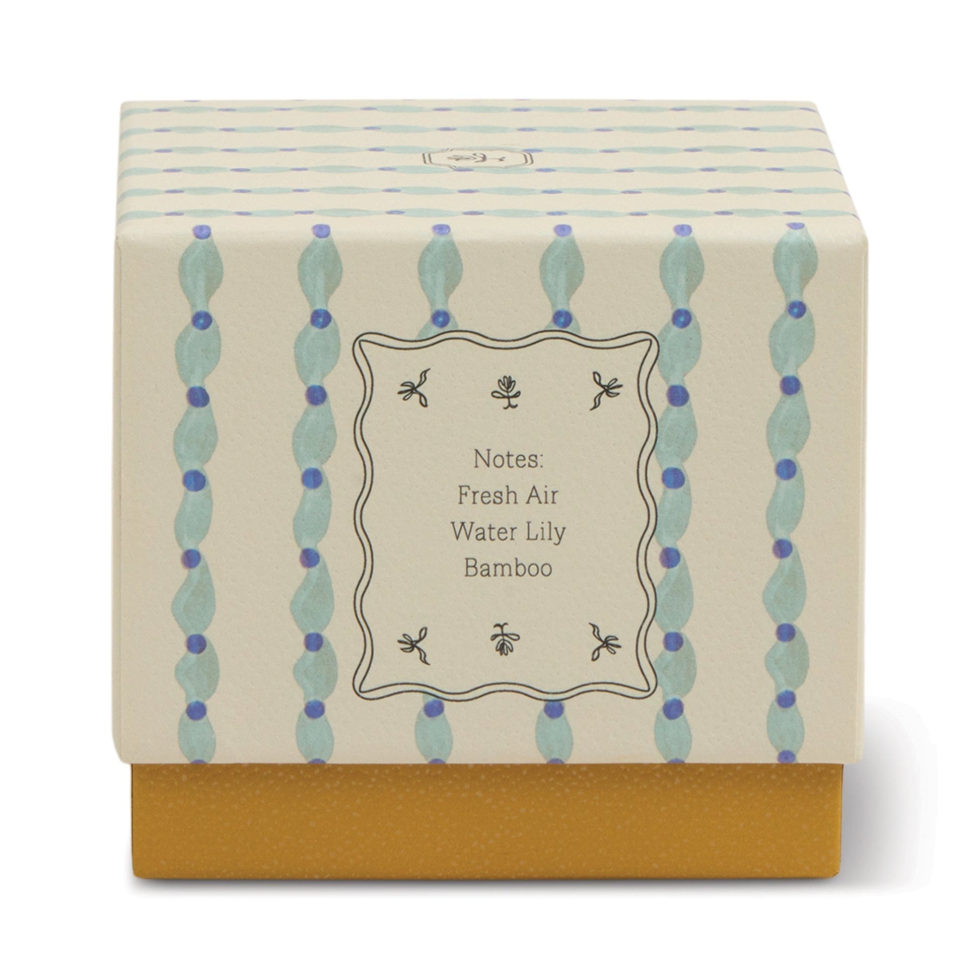The Wisteria & Willow - Tulip 5.5 oz Candle comes in a decorative botanical box with a cream and blue patterned lid labeled Fresh Air, Water Lily, Bamboo. Its solid mustard yellow base is perfect for teal glass vessels or wisteria candles.