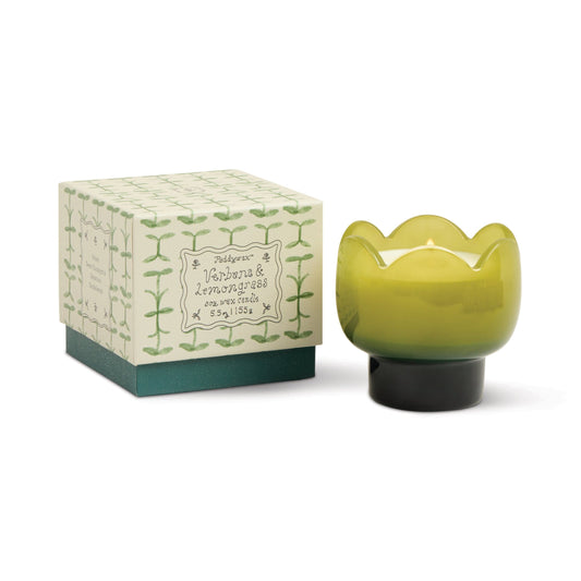 A green, tulip-shaped vessel holds the Verbena & Lemongrass - Tulip 5.5 oz Candle beside a decorative box with a leaf pattern and text describing the scent and weight.