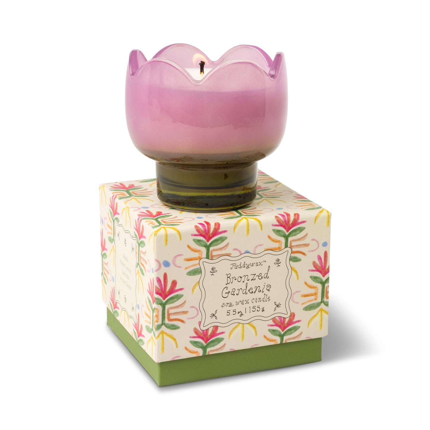 The Bronzed Gardenia - Tulip 5.5 oz Candle features a pink, flower-shaped design in a glass holder atop a decorative floral box, making it perfect for adding a charming floral touch to any room.