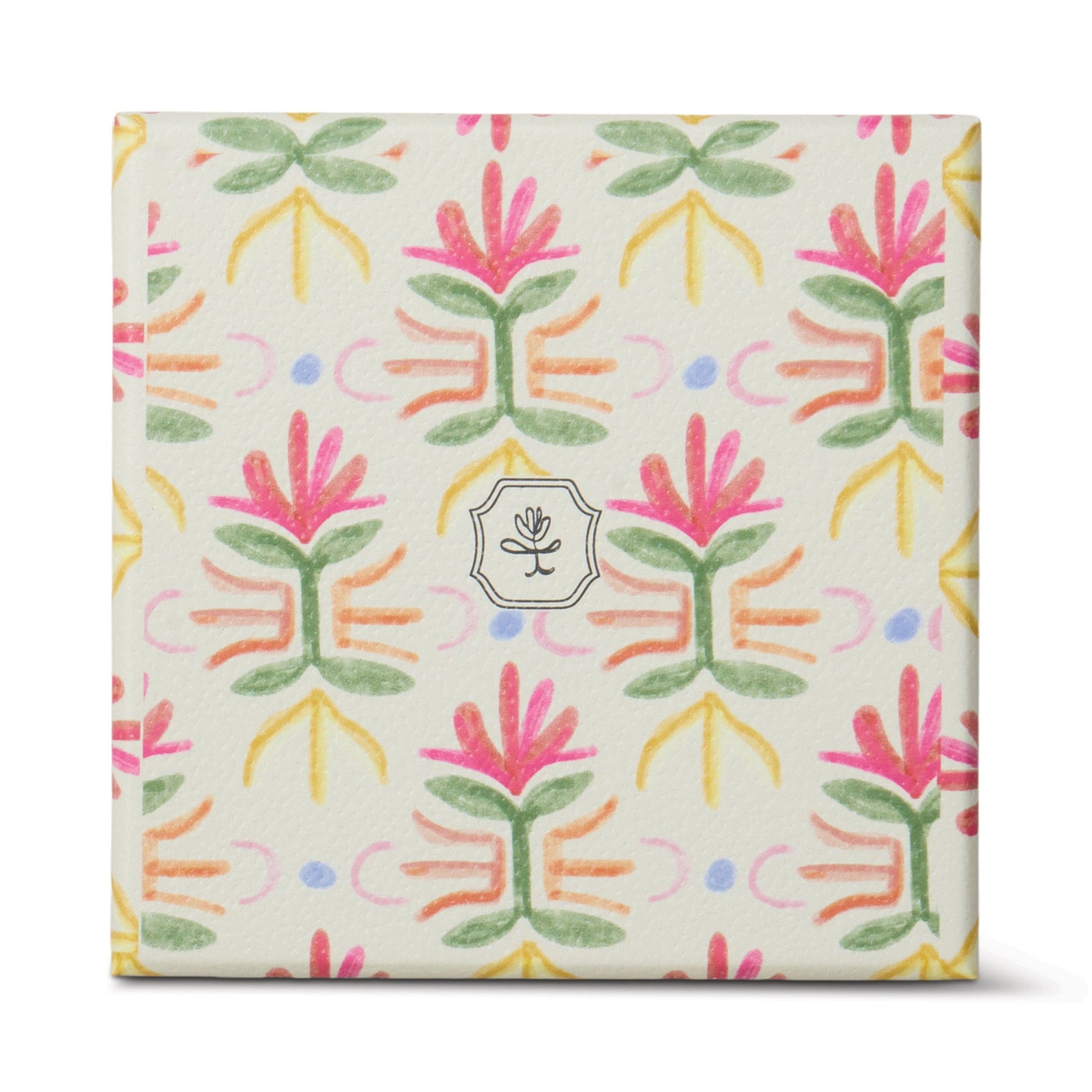 The Bronzed Gardenia - Tulip 5.5 oz Candle comes in a square box with a colorful floral pattern in pink, green, yellow, and purple on white, featuring a small circular flower logo—perfect for adding floral charm to your home décor.