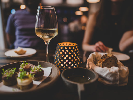 Candlelit dining with wine glass and appetizers